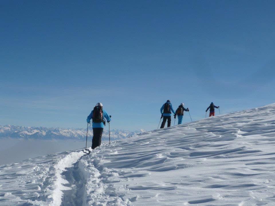 skieurs en randonnée se suivent sur une trace dans la neige.